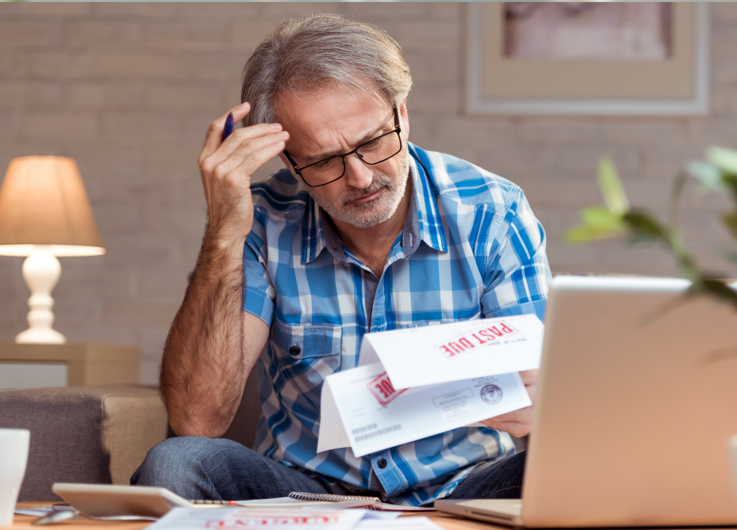 A man is sitting at a table looking at a bill.