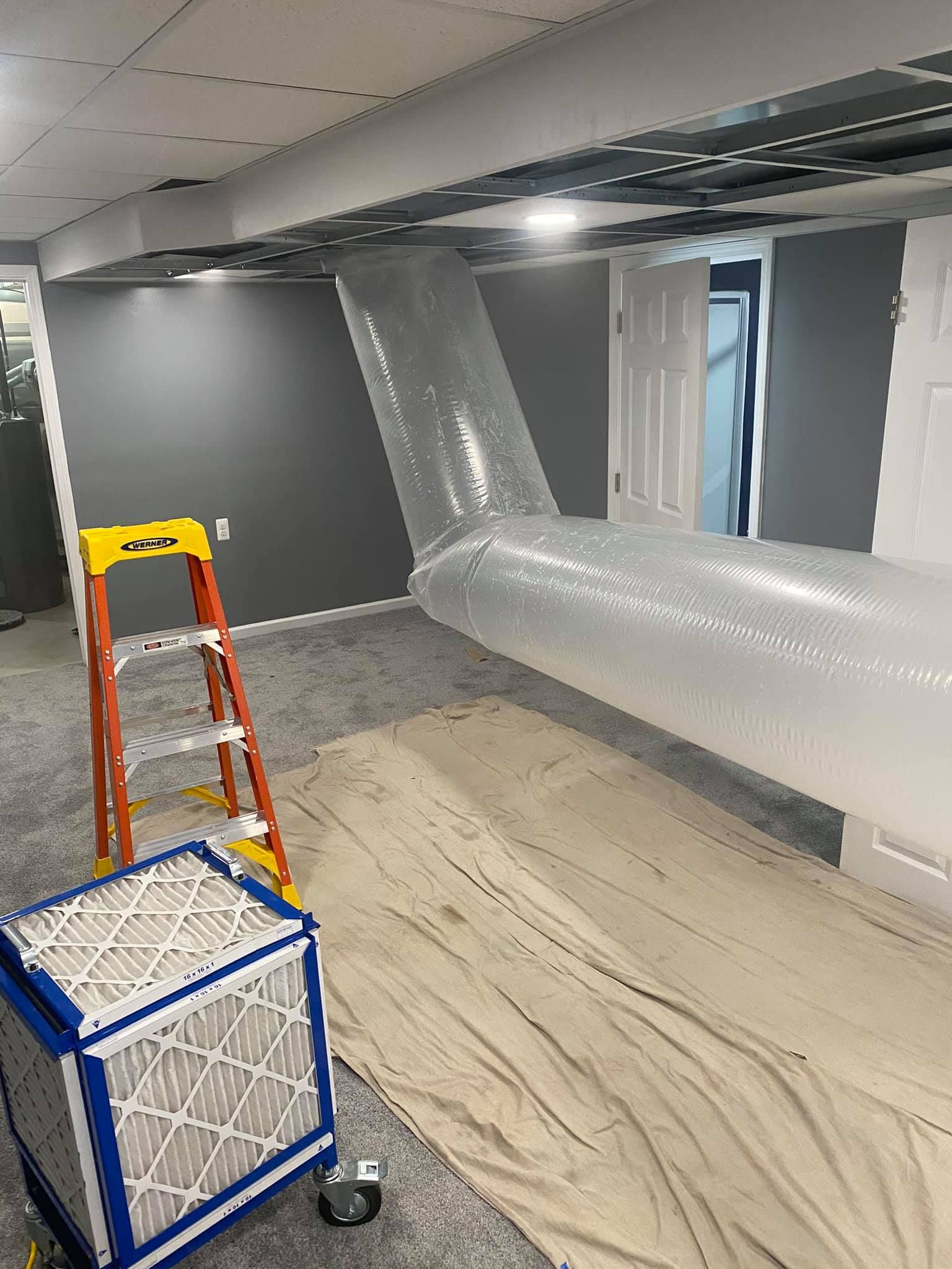 A room with a ladder and a box of filters in it.