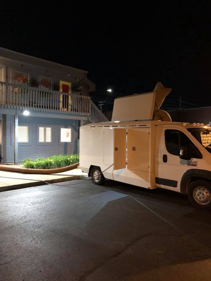 A white van is parked in front of a building at night.
