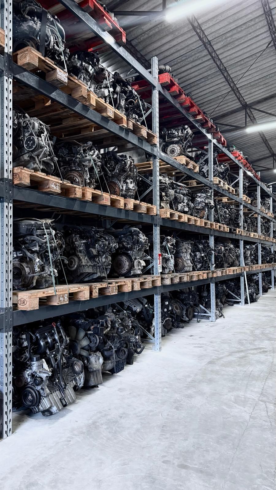 File di motori di automobili sugli scaffali di un magazzino.