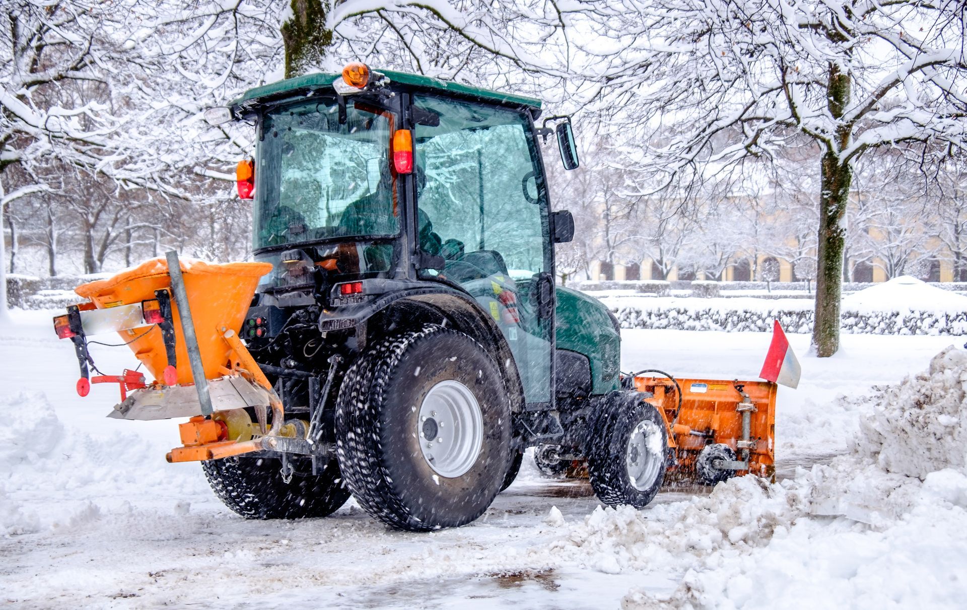 ein Traktor mit einem orangefarbenen Schneepflug