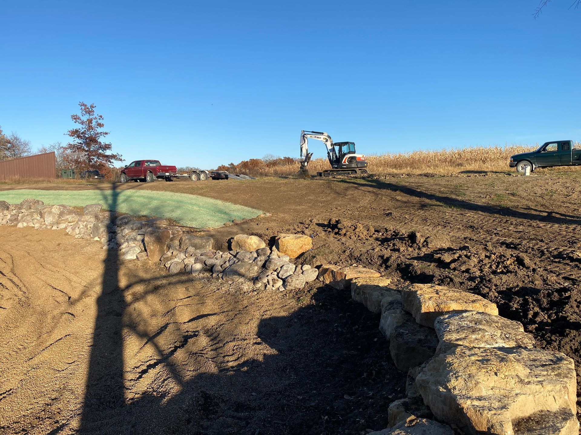 A tractor is digging a hole in the dirt in a field.