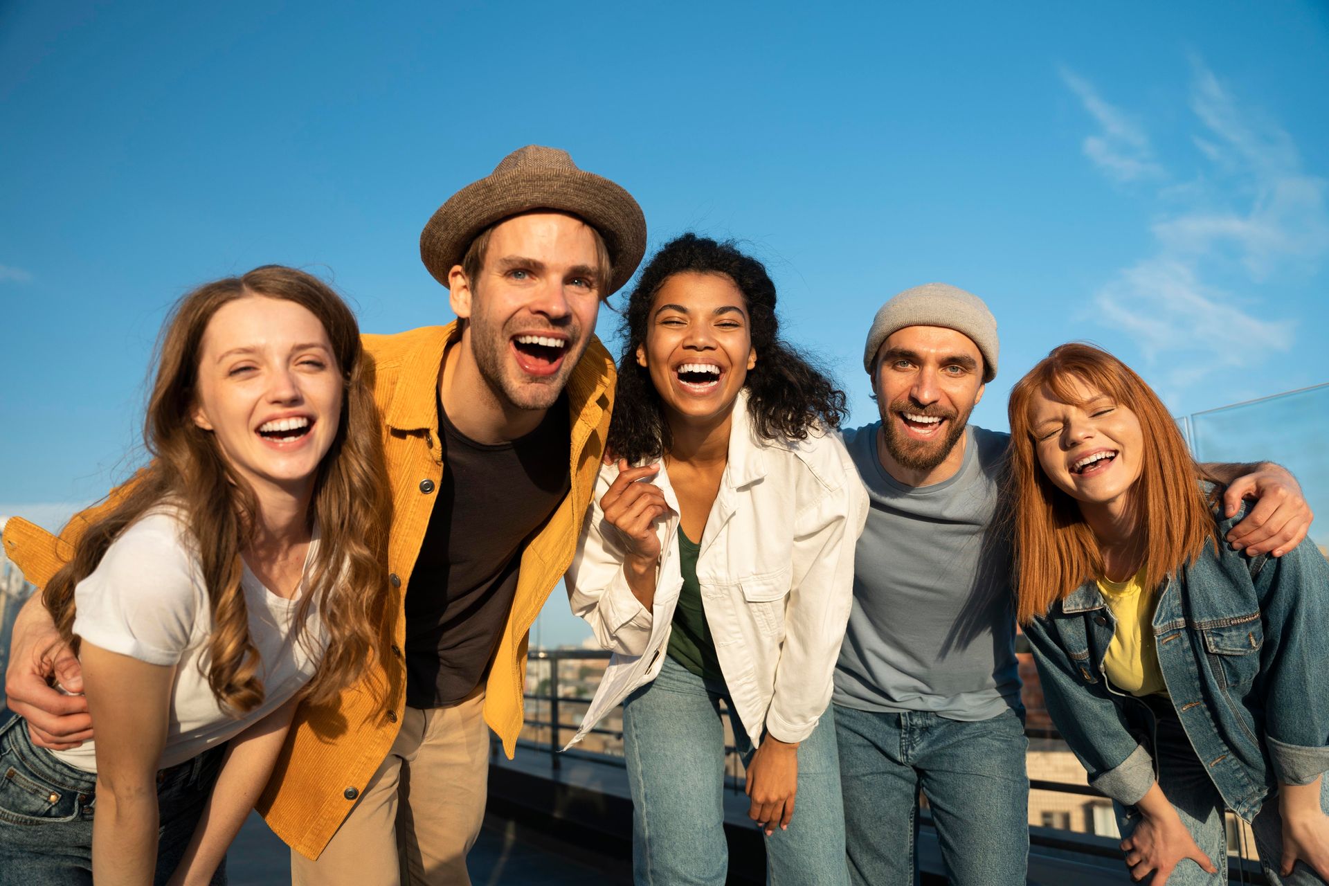 A group of young people are posing for a picture on a rooftop.