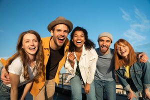 A group of young people are posing for a picture on a rooftop.