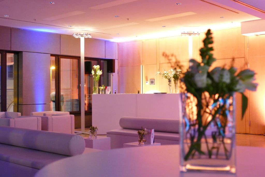 Gemütliche Loungeatmosphäre, gedämpftes Licht, weißes Mobiliar