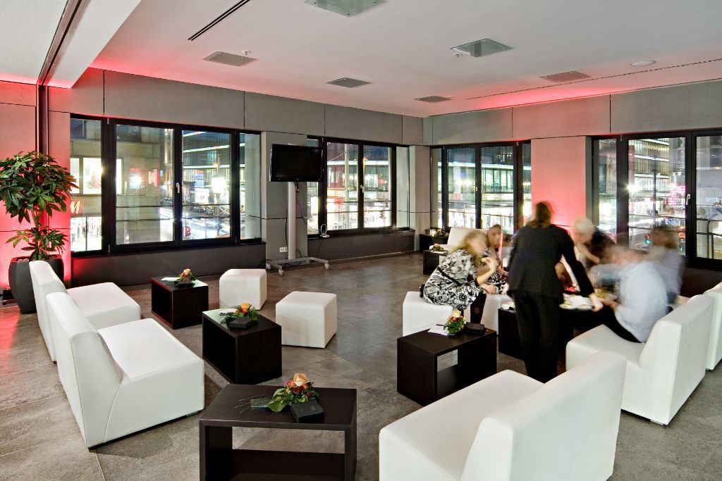 Gemütliche Loungatmosphäre mit schwarzen und weißen Polstermöbeln, Sofas und Poufs