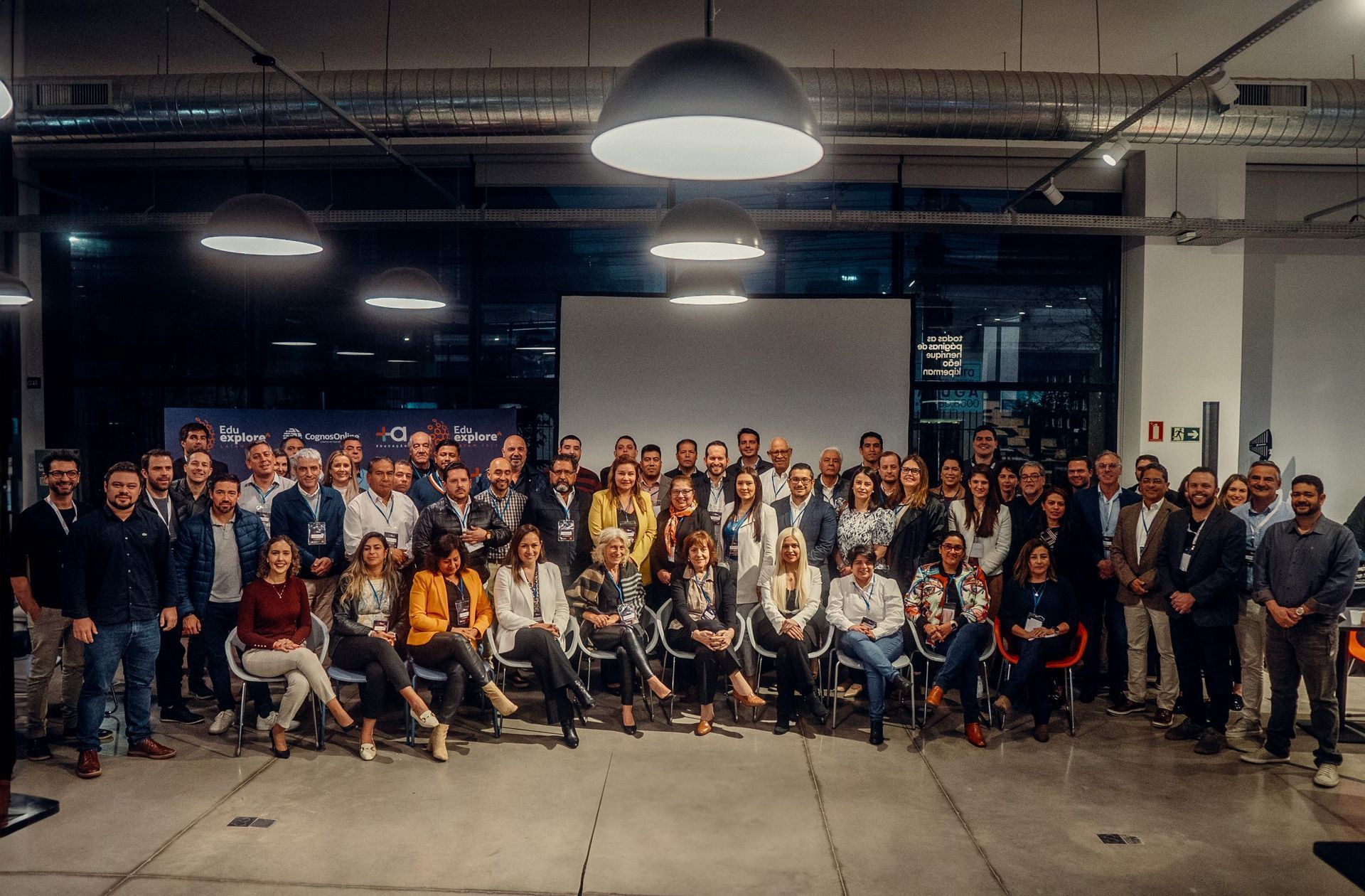 Participantes reunidos em grupo posam sorrindo para foto ao final do evento