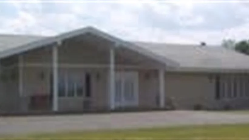 A large house with a large porch and a driveway.