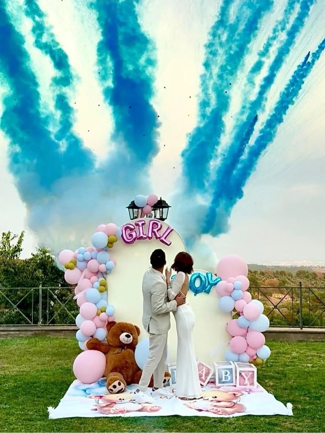 Coppia che si abbraccia durante la rivelazione del sesso del nascituro con fumo blu