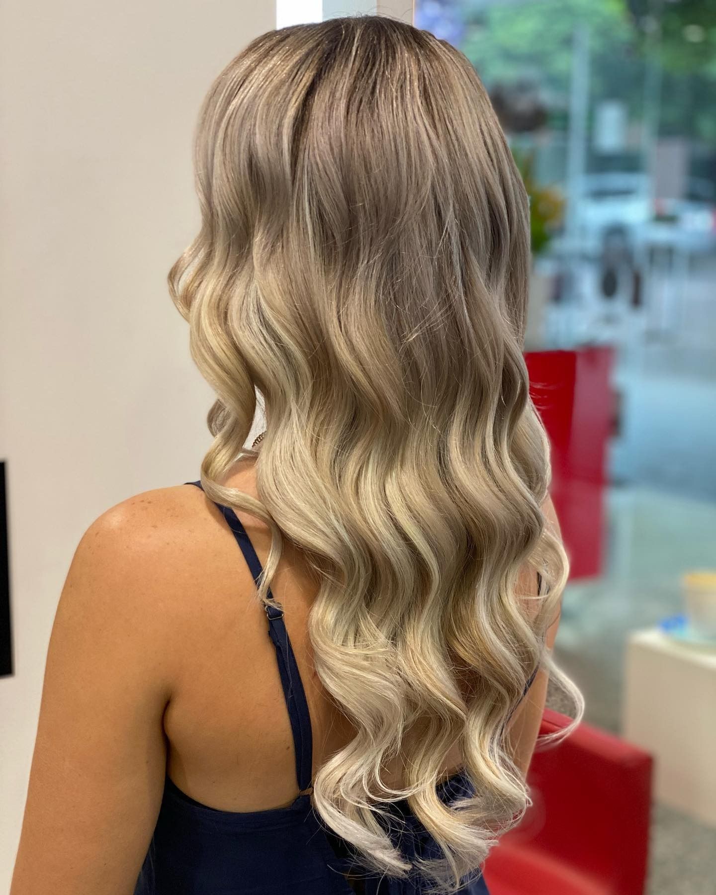 Side Profile of a Woman With Blonde Wavy Hair in a Salon, With Red Counters — @miilan in Darwin City, NT