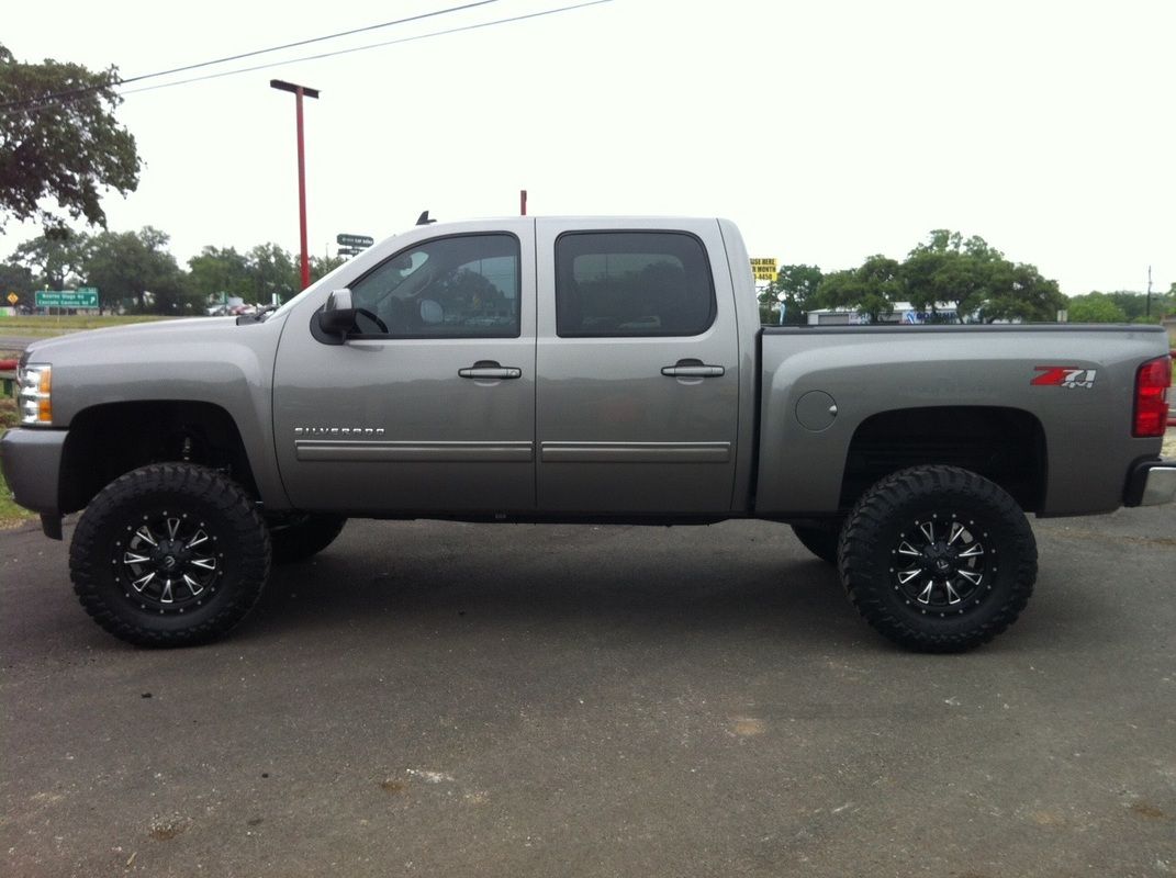 A silver pickup truck is parked in a parking lot.