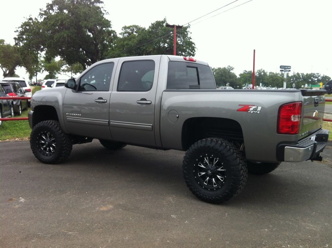 A silver truck is parked on the side of the road