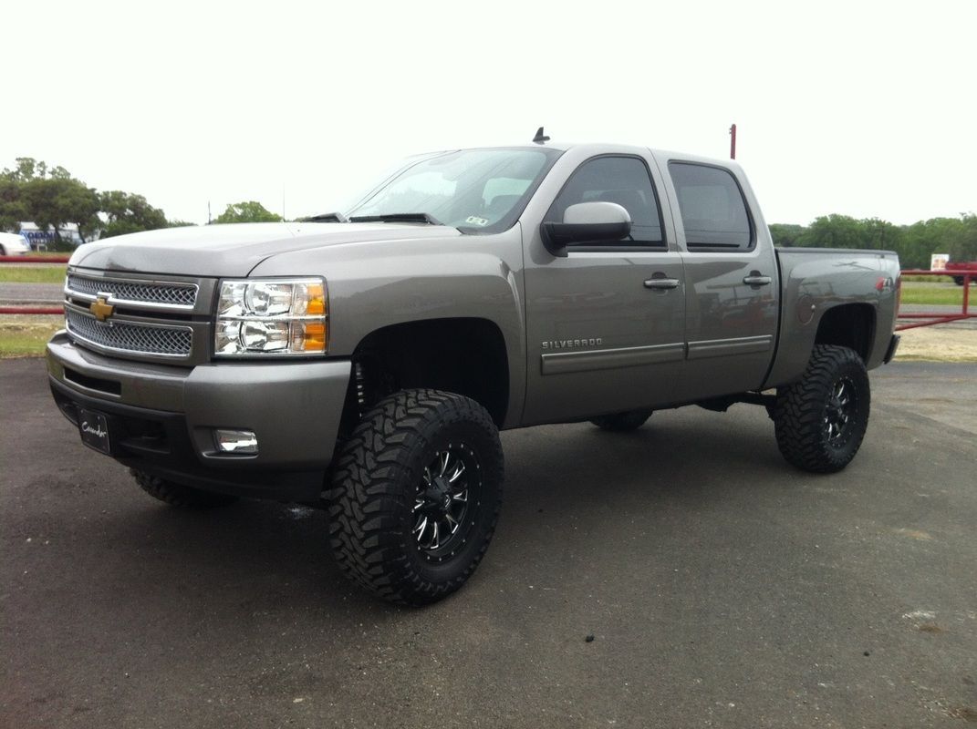 A gray pickup truck is parked in a parking lot.