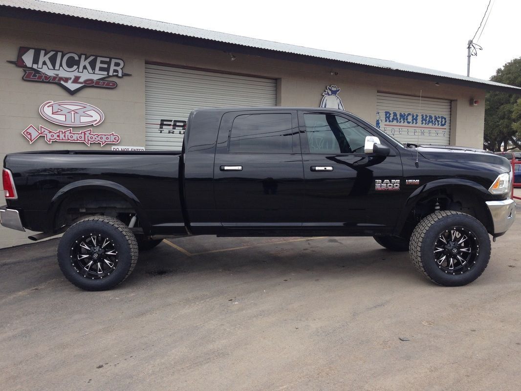 A black truck is parked in front of a building.