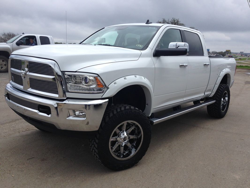 A white dodge ram truck is parked in a parking lot.