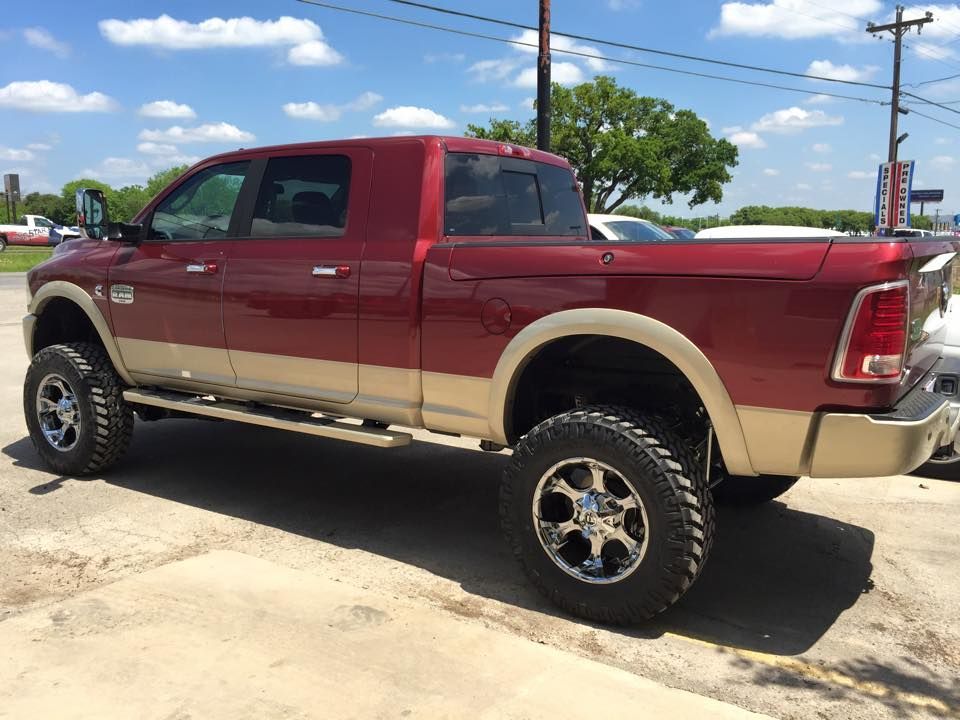 A red dodge ram truck is parked in a parking lot.