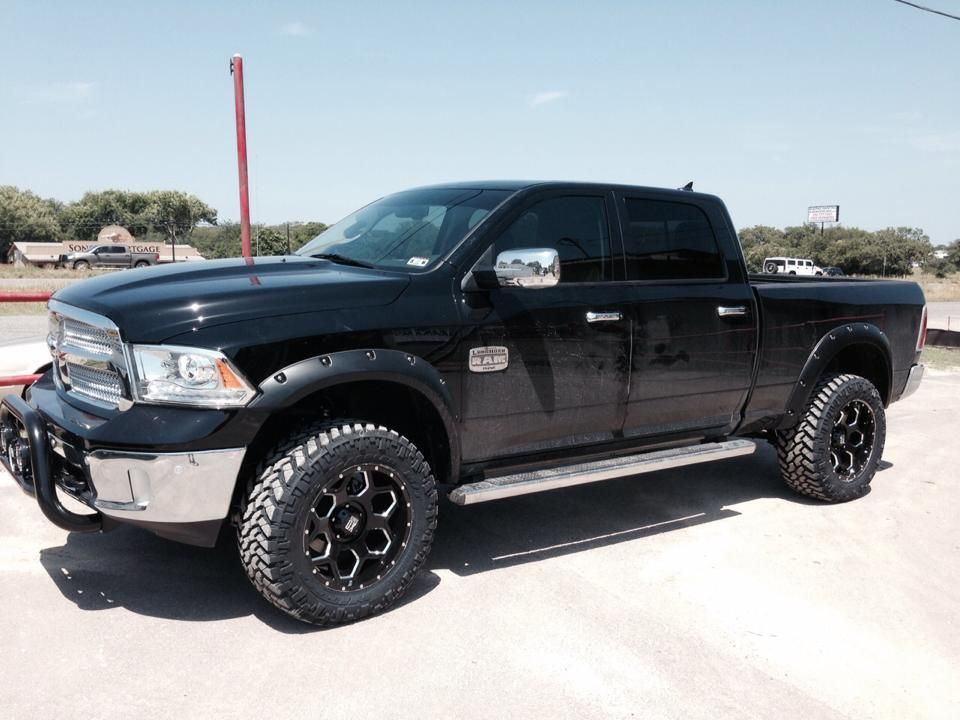 A black dodge ram truck is parked on the side of the road.