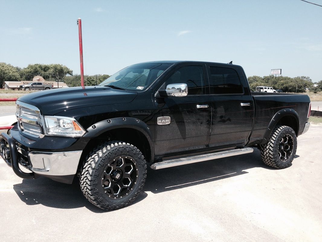 A black dodge ram truck is parked on the side of the road.