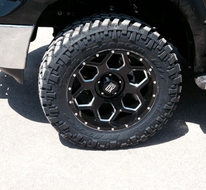 A close up of a tire on a black truck