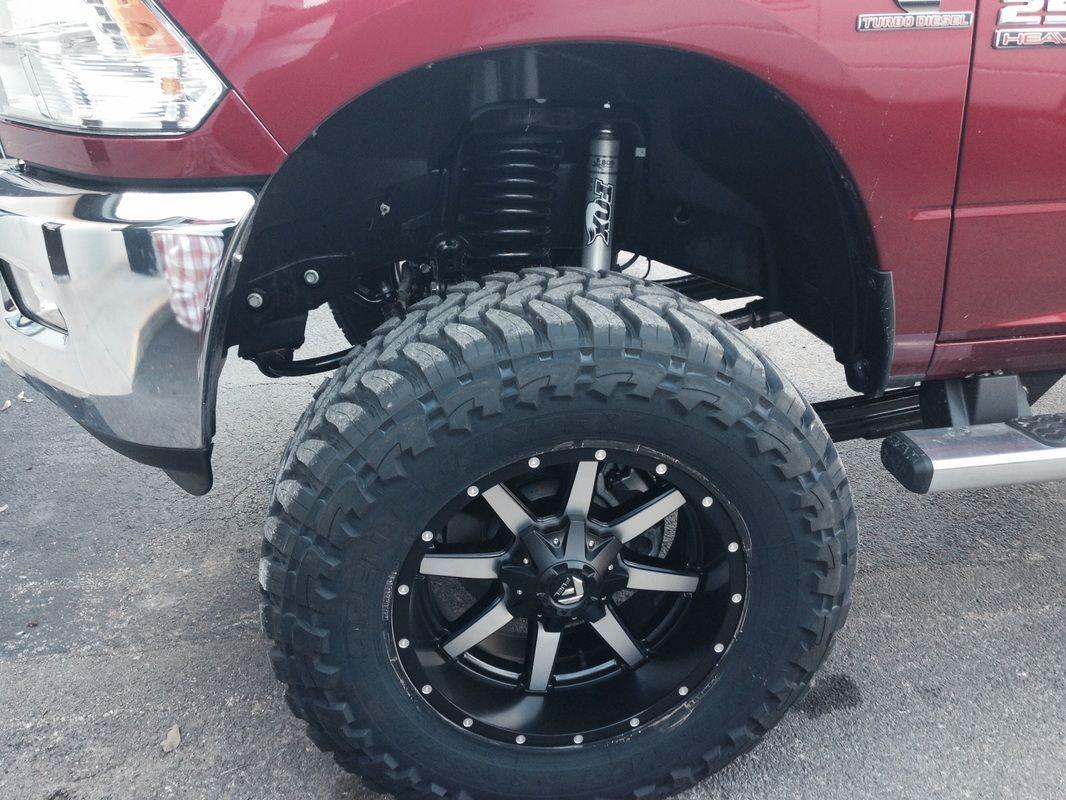 A red truck with black and white wheels and tires