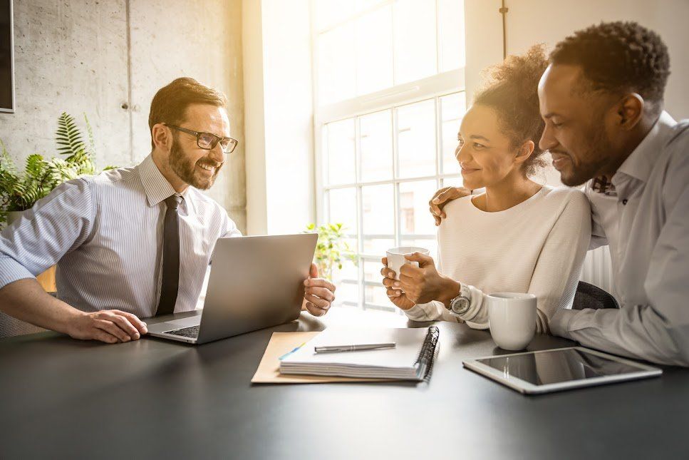 A man is sitting at a table with a laptop and a couple.