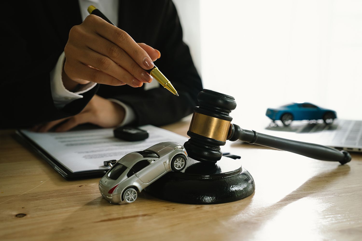 A lawyer uses a gavel near a toy car.
