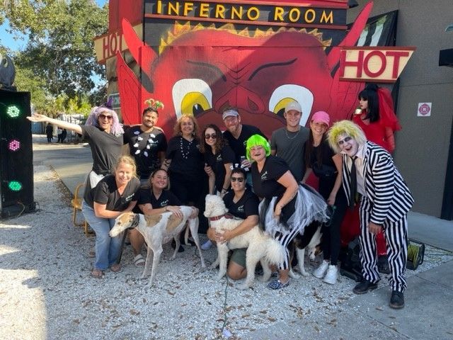 A group of people posing in front of a sign that says inferno room hot