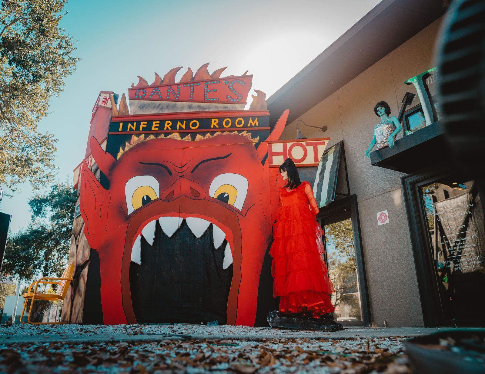 A woman in a red dress is standing in front of an inferno room.