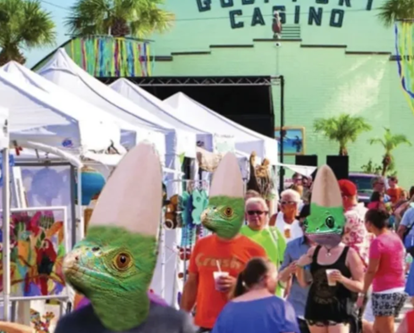 People wearing lizard masks are walking in front of a building that says casino