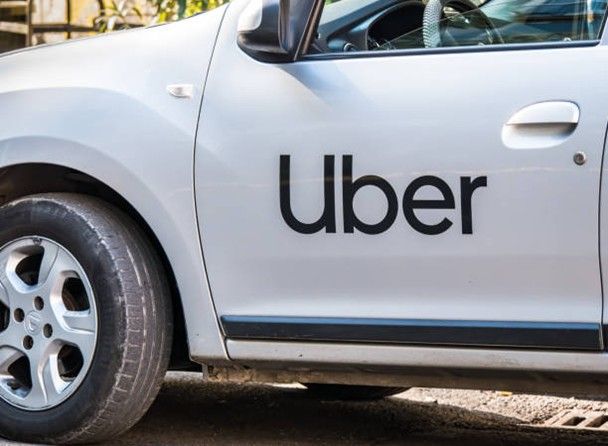 White Uber car with black logo on the door.