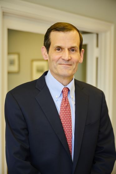 A man in a suit and tie is smiling for the camera