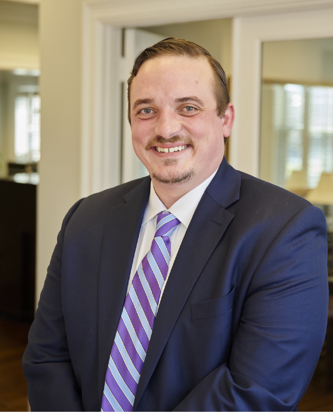 A man in a suit and tie is smiling for the camera.