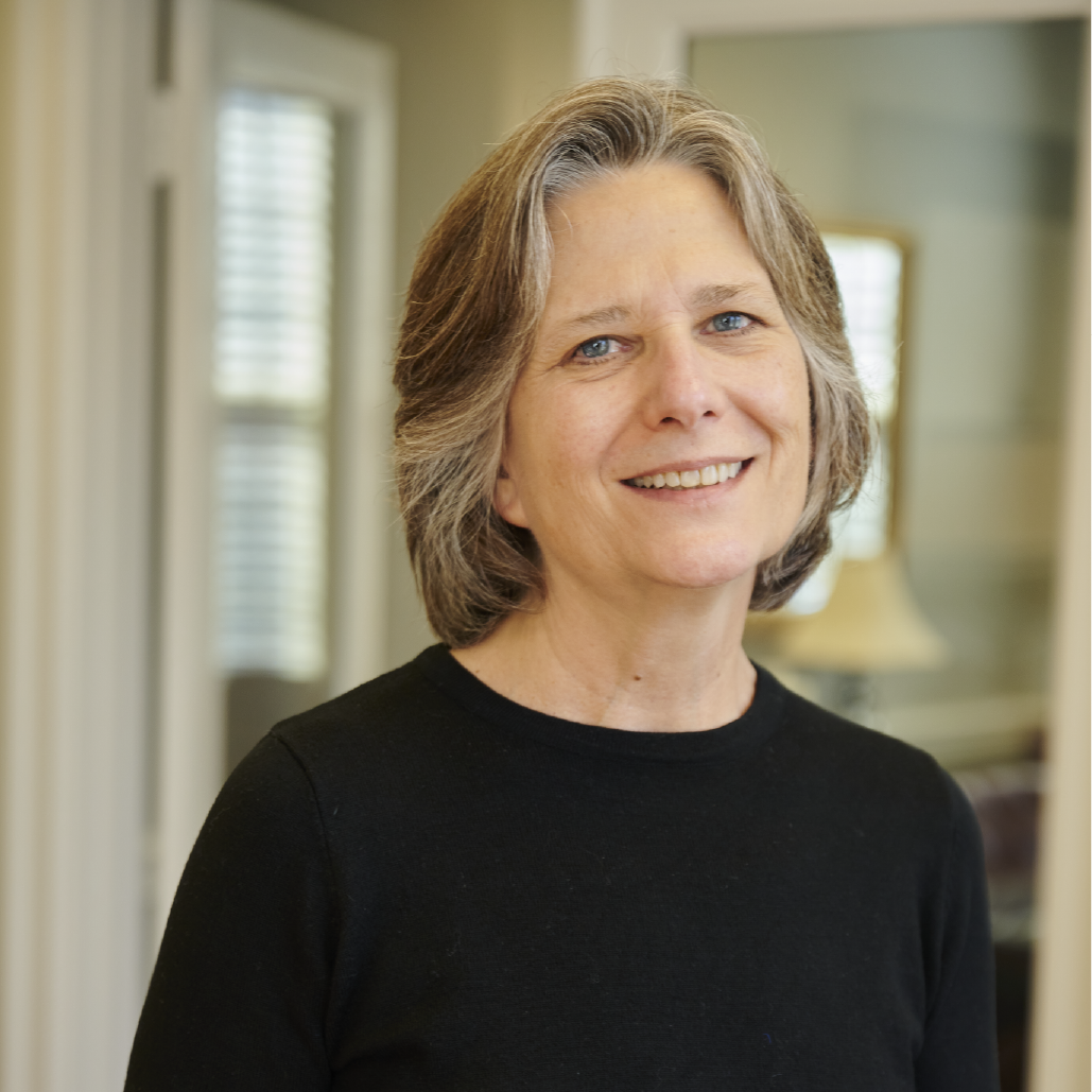 A woman in a black shirt is smiling for the camera