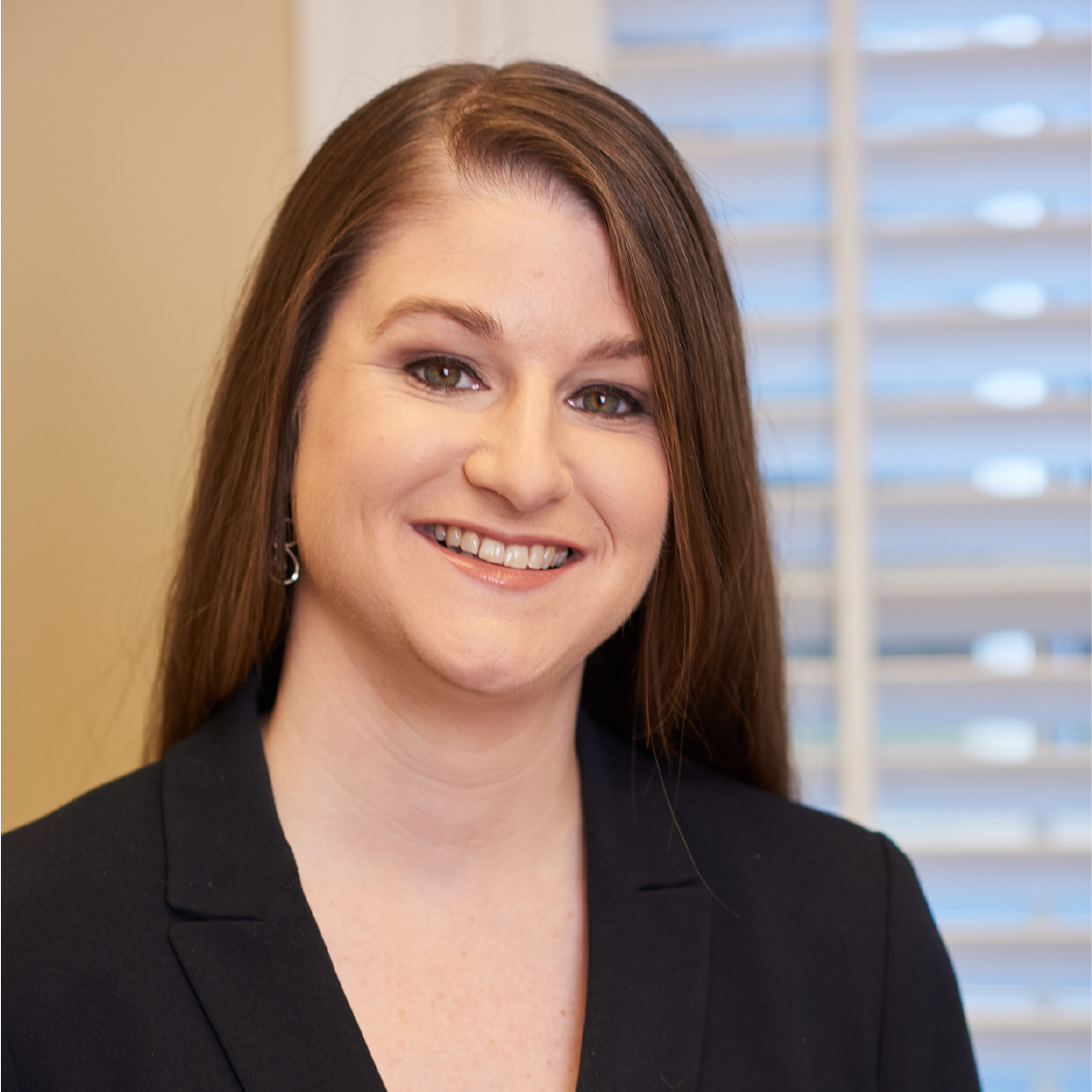 A woman in a black jacket is smiling for the camera.