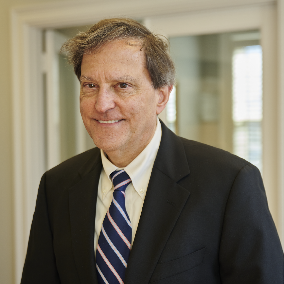 A man in a suit and tie is smiling for the camera