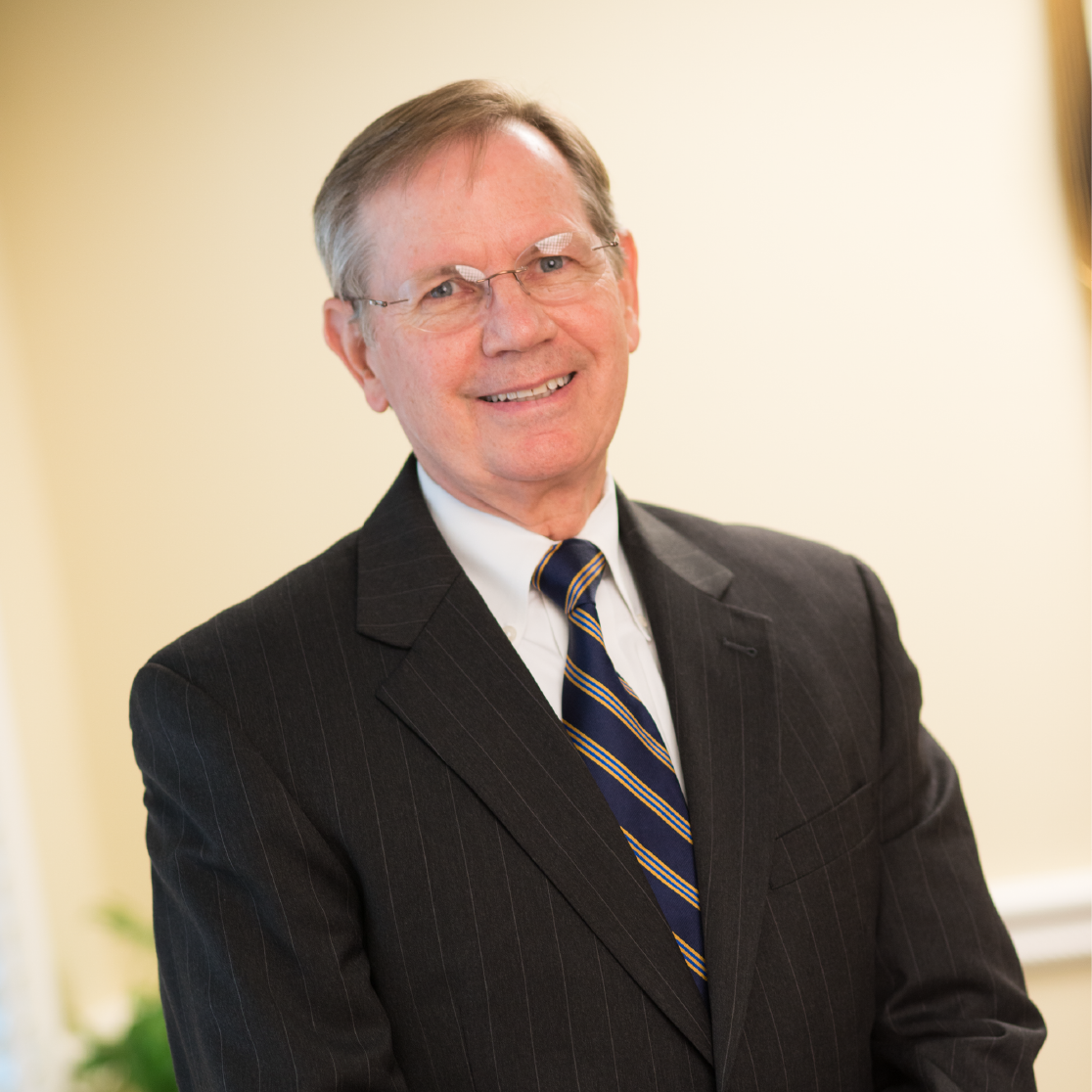 A man in a suit and tie is smiling for the camera