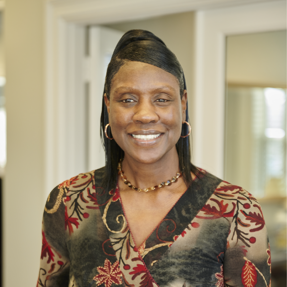 A woman in a floral shirt is smiling for the camera