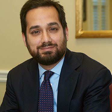 A man with a beard is wearing a suit and tie.