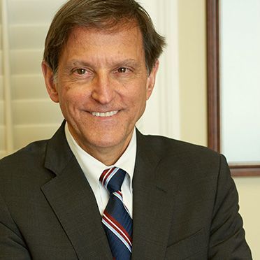 A man in a suit and tie is smiling for the camera.