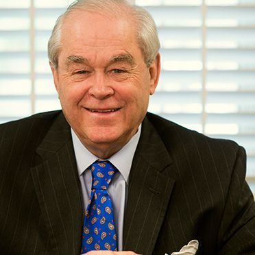 A man in a suit and tie is smiling for the camera