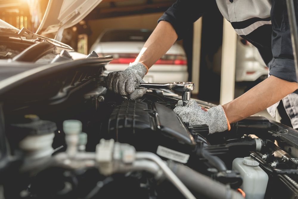 A Mechanic is Working on the Engine of a Car in a Garage — Fix-It Automotive in Corrimal, NSW
