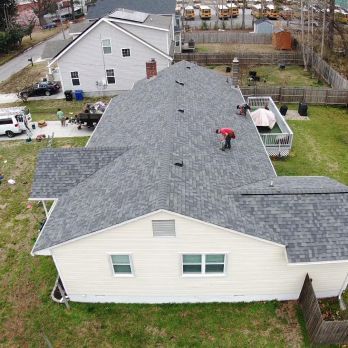 An aerial view of a house with a new roof being installed.