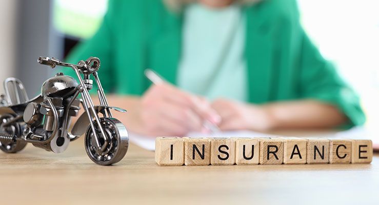 A woman is signing a motorcycle insurance policy.