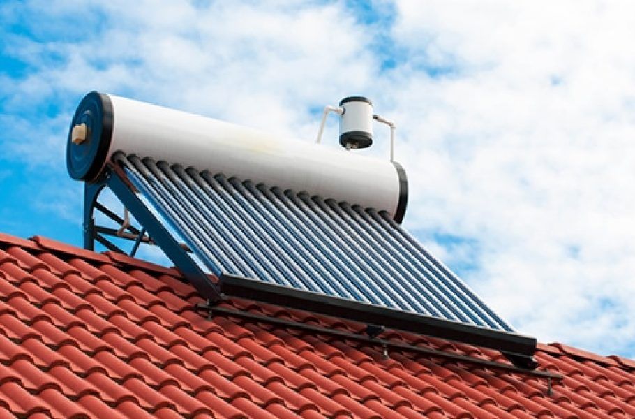 Solar Water Heater on a Red Tile Roof Against a Cloudy Blue Sky — Expert Plumbing & Solar Services Bathurst in Kelso, NSW