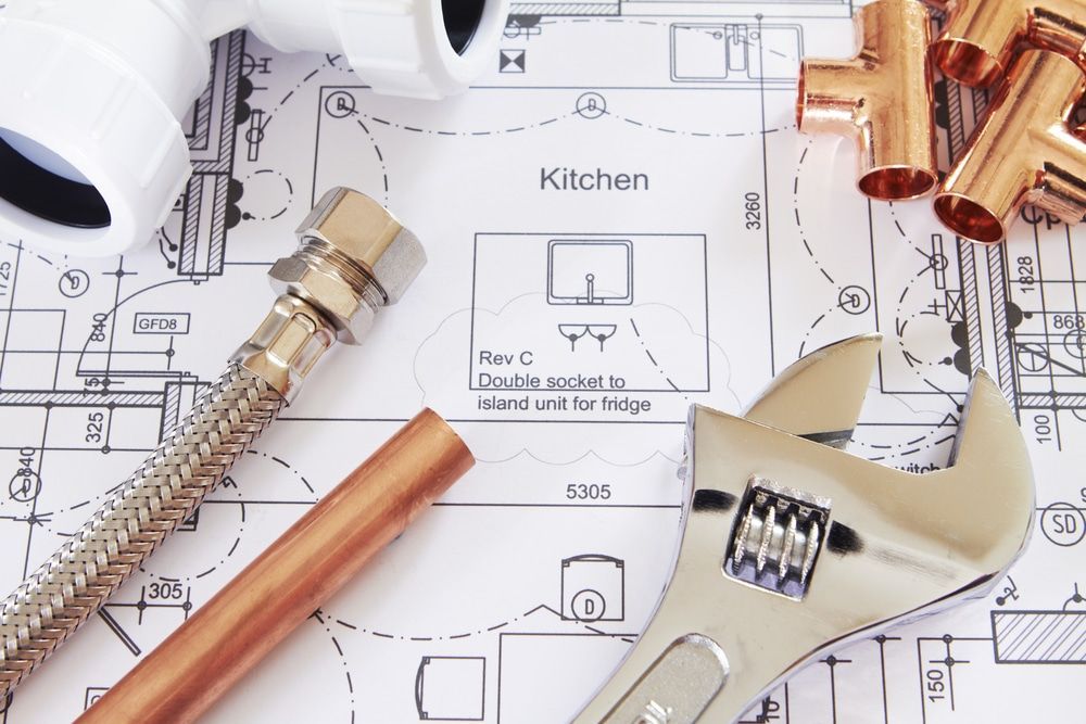 Plumbing Tools and Pipes Arranged on Top of a Blueprint for a Kitchen — Expert Plumbing & Solar Services Bathurst in Oberon, NSW