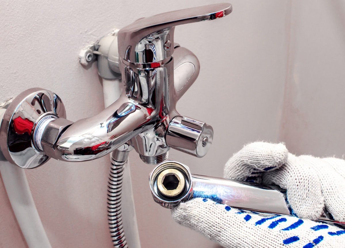 Person Wearing Gloves Installing a Chrome Faucet — Expert Plumbing & Solar Services Bathurst in Kelso, NSW