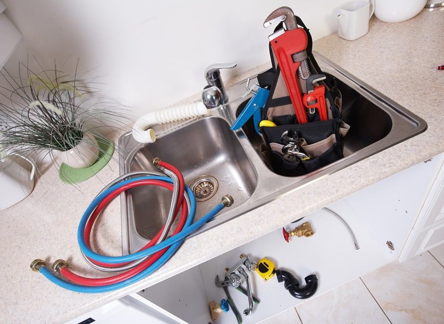 Plumbing Tools in Kitchen Sink, Including Wrench, Hoses — Expert Plumbing & Solar Services Bathurst in Lithgow, NSW