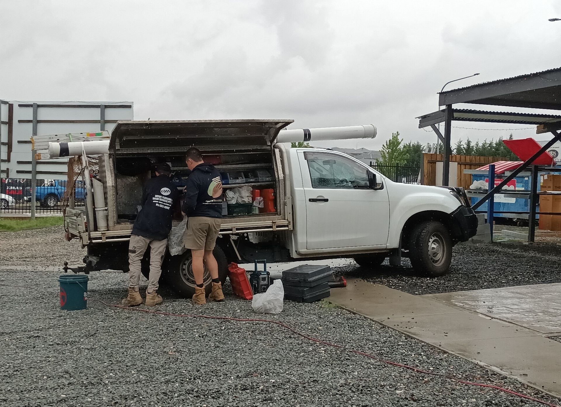 Two Workers by a White Pickup Truck With Open Canopy — Expert Plumbing & Solar Services Bathurst in Kelso, NSW