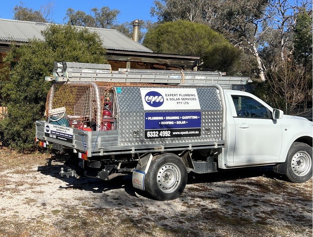 Two Men Standing Near a Plumbing Truck, One Holding a Wire — Expert Plumbing & Solar Services Bathurst in Kelso, NSW