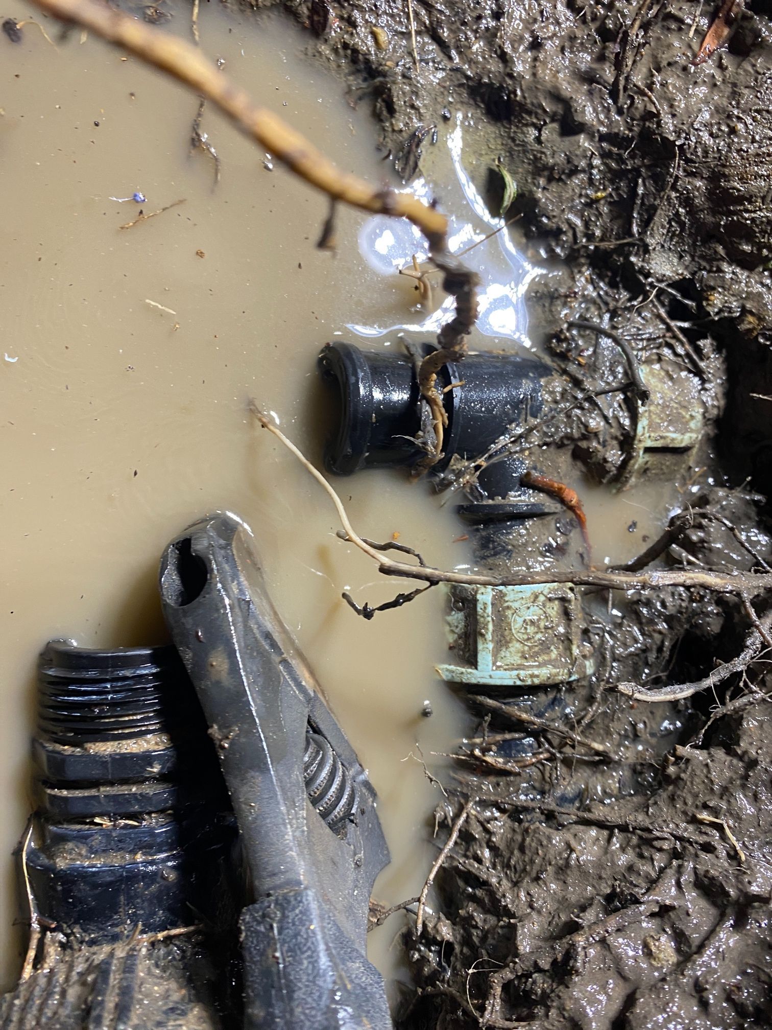 Wrench Attempting to Tighten Fitting on Irrigation Pipe in Muddy Water — Expert Plumbing & Solar Services Bathurst in Orange NSW